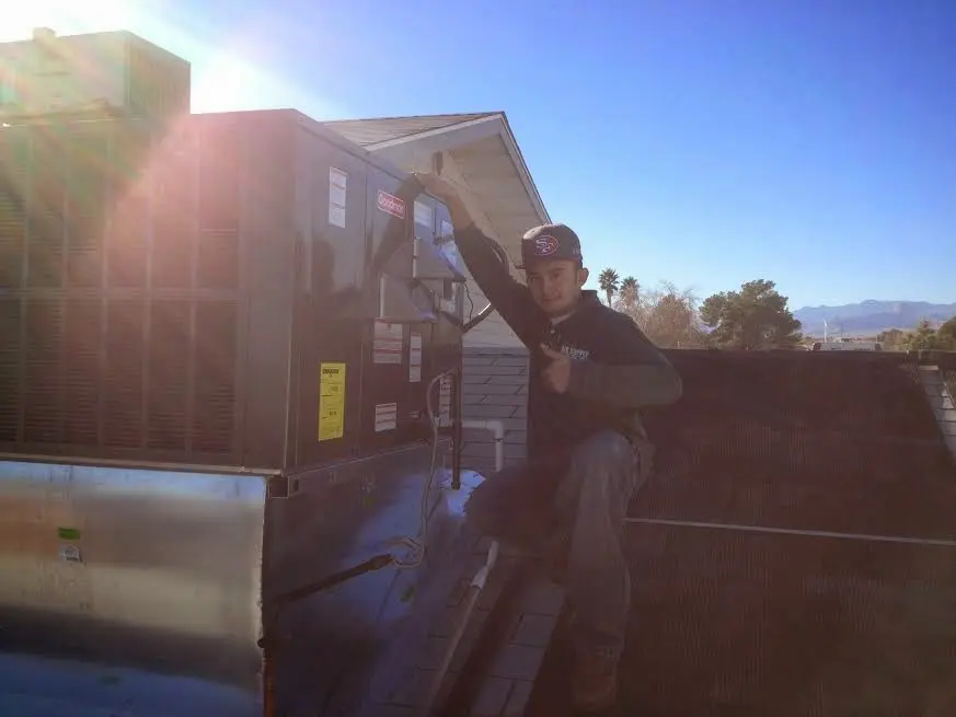 HVAC technician performing AC Tune-Up on a rooftop unit in Aiea